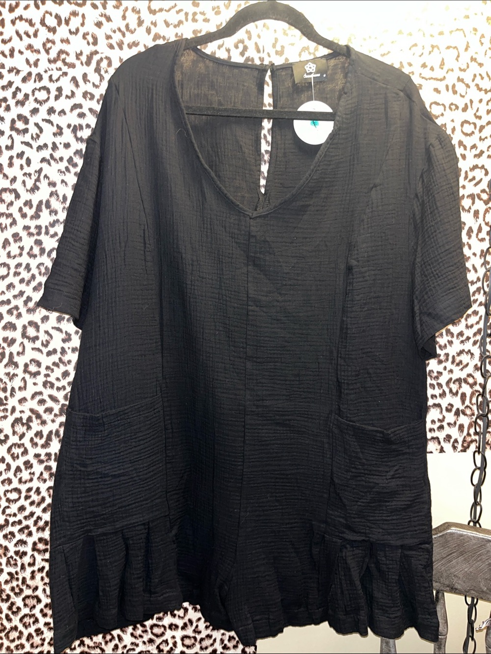 Black skirted romper with pockets.
